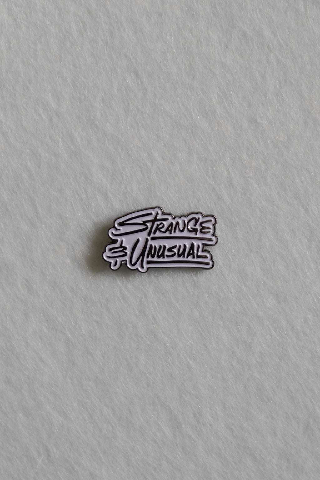 Strange and Unusual Enamel Pin